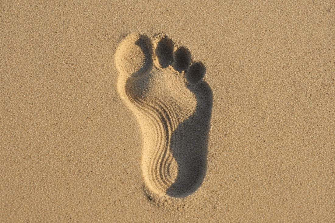 Deep heel print in sand showing why heel support is the foundation of healthy foot structure
