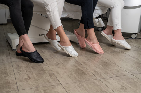 Medical professional's feet in orthopedic footwear on hospital floor showing the deliberate choice of proper foot support